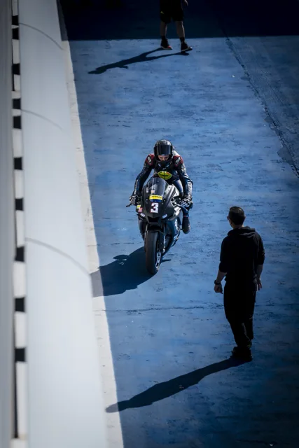 Pilota sulla moto numero 3 nella pit lane blu